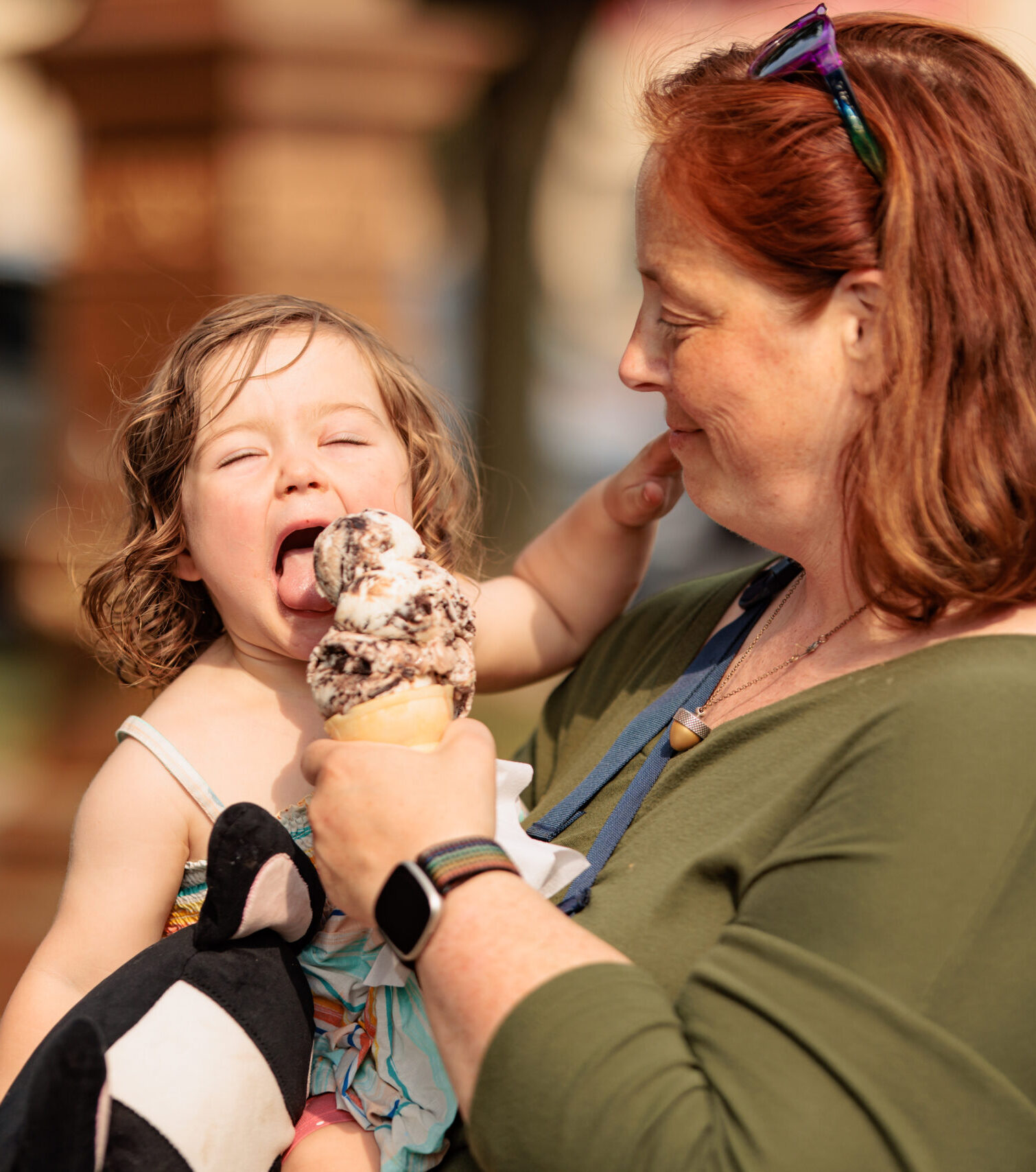 Woman holding a child eating ice cream